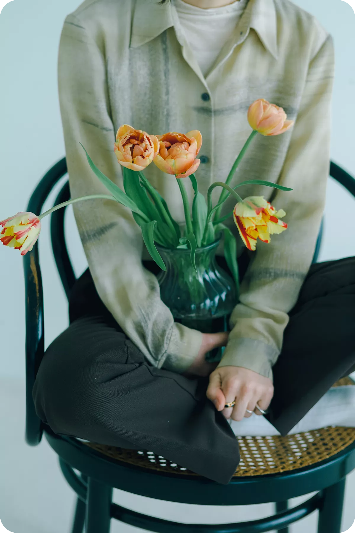 花を抱えて椅子に座っている女性