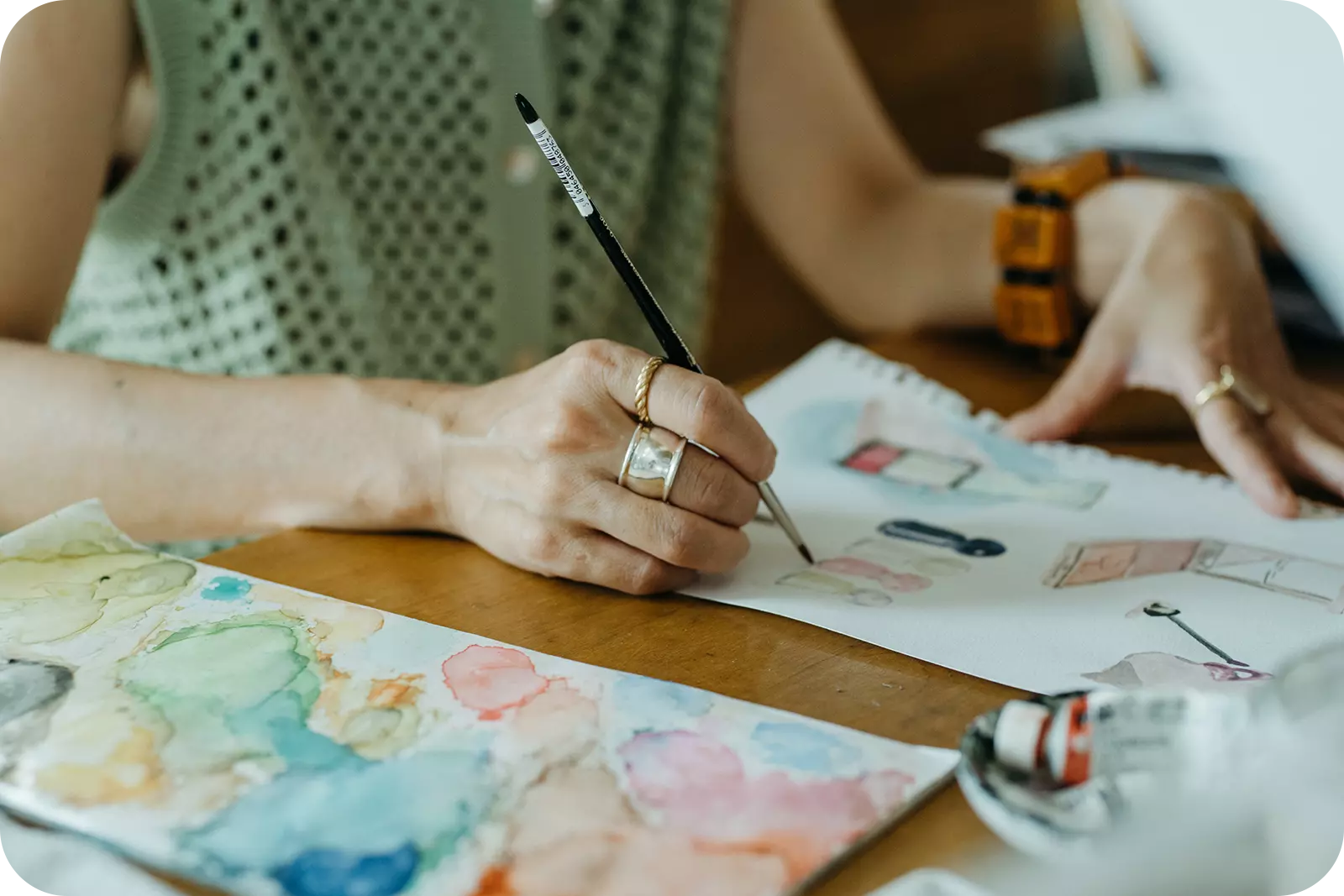 絵の具と筆で素敵な絵を描く女性の手